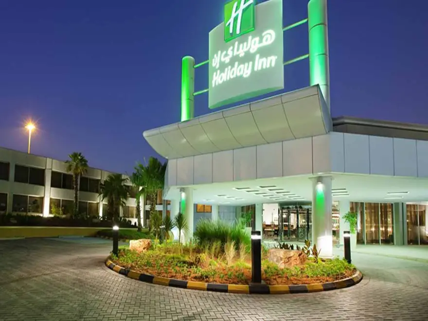 Illuminated entrance of Holiday Inn Al Qasr Riyadh at dusk